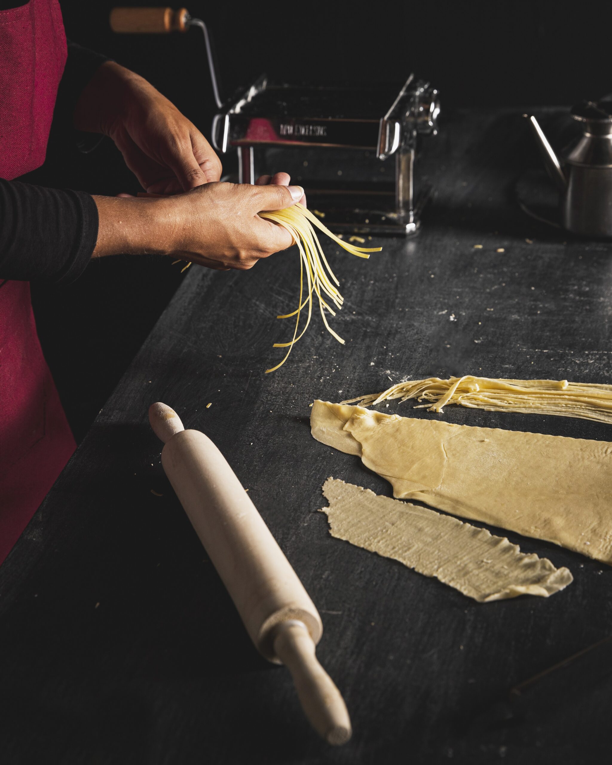 close up person preparing pasta
